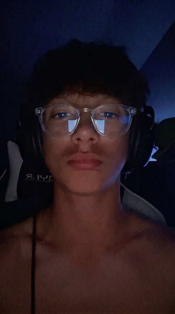Adapt Dew customer wearing transparent frame glasses with headset, real customer photo