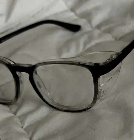 Close-up of Adapt Dew glasses resting on a blanket